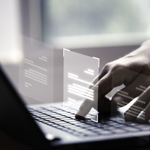 Laptop displaying ghosted document images, representing digital document security.