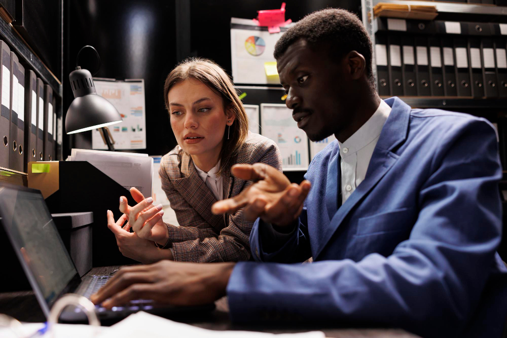 A man and woman looking at a computer screen in the wake of the Crowdstrike outage