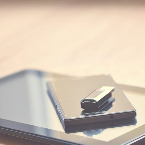 USB stick and paper with text overlay exploring photocopy definition for digital and physical documents. Short, descriptive.